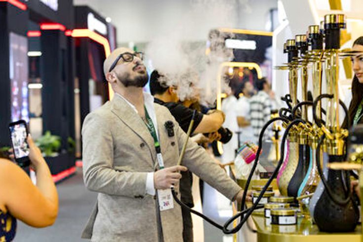 往届 World Shisha Dubai 展会现场，参观者在展位查看水烟